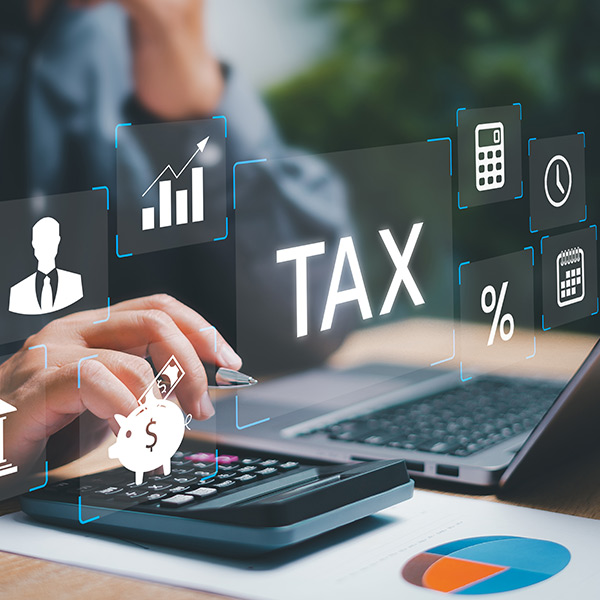 Hands on a laptop and calculator representing a person paying taxes